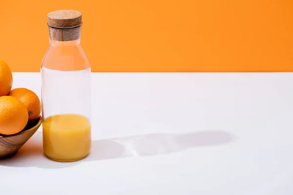 Suco Laranja Fresco Garrafa Vidro Perto Laranjas Tigela Madeira Superfície — Fotografia de Stock