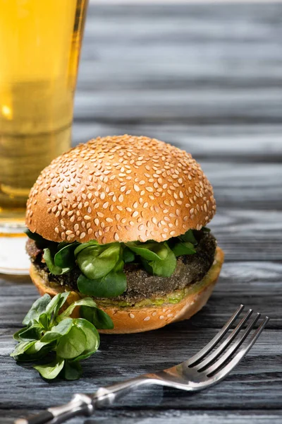 选择重点的美味蔬菜汉堡包 配上微量蔬菜 配上啤酒和叉子 放在木制桌子上 — 图库照片