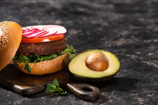 Smaczne Wegańskie Burger Warzywami Serwowane Awokado Pół Drewnianej Desce Krojenia — Zdjęcie stockowe