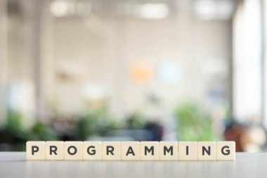 Ofis masasında programlama yazıları olan beyaz küpler 