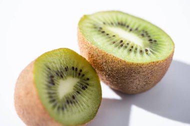 Beyazın üzerindeki yeşil kiwifruit yarımlarını kapat 