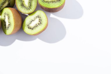 top view of fresh and ripe kiwifruit halves on white  clipart