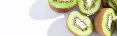 panoramic crop of fresh and ripe kiwifruit halves on white  clipart