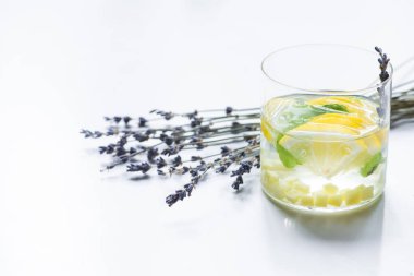 Taze zencefilli limonata ve beyaz arka planda nane ve lavanta dalı.