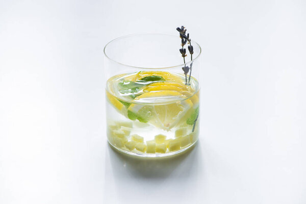 fresh ginger lemonade in glass with mint and lavender branch on white background