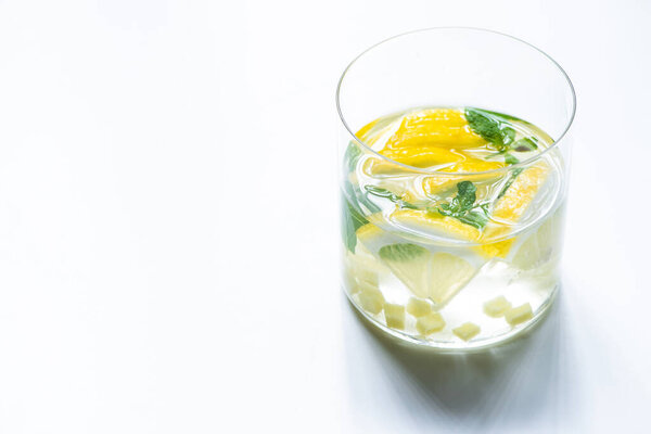 fresh ginger lemonade in glass with lemon and mint on white background