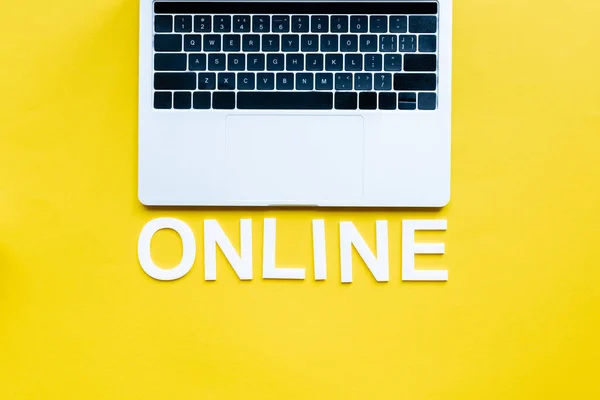 Draufsicht Auf Laptop Und Online Schriftzug Auf Gelber Fläche — Stockfoto