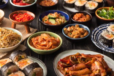 Geleneksel kimchi ve topokki 'nin seçici odak noktası ahşap yüzeydeki lezzetli Kore yemekleri. 