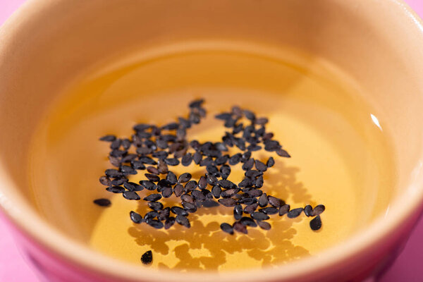 close up of oil with black sesame in bowl 