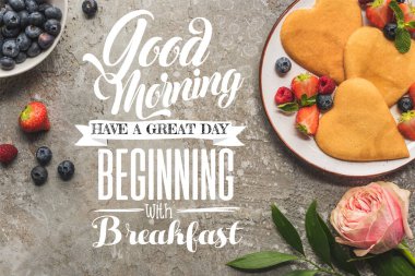 top view of heart shaped pancakes with berries on grey concrete surface near rose, good morning, have great beginning with breakfast illustration clipart