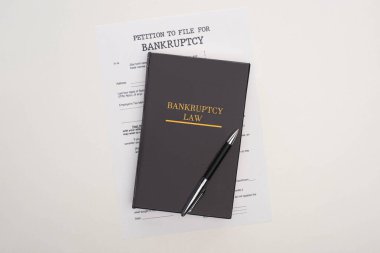 top view of bankruptcy paper, law book and pen on white background clipart