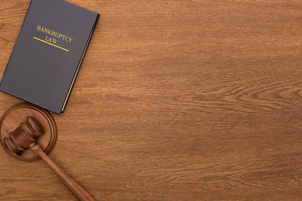 top view of bankruptcy law book and gavel on wooden background