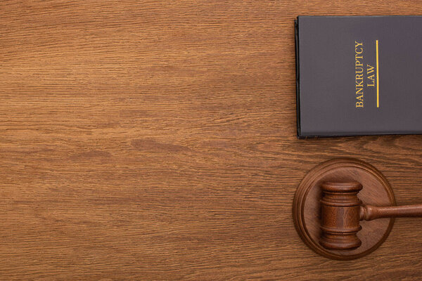 top view of bankruptcy law book and gavel on wooden background