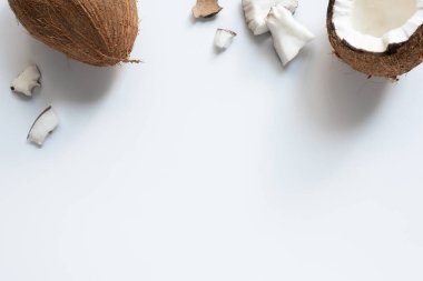 top view of whole and cracked tasty coconut half and pieces on white background clipart