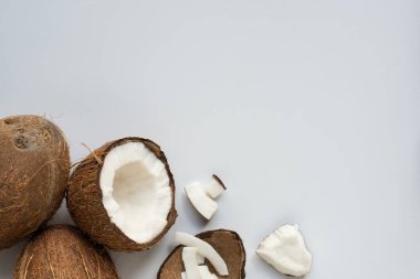 top view of fresh tasty cracked coconuts with flakes and shell on white background clipart