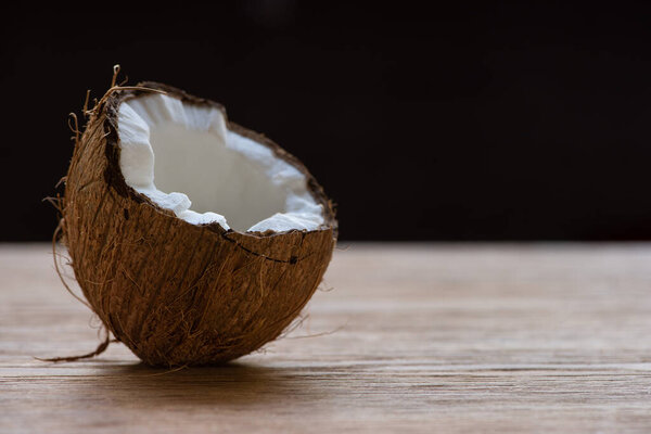 fresh tasty coconut half on wooden table isolated on black