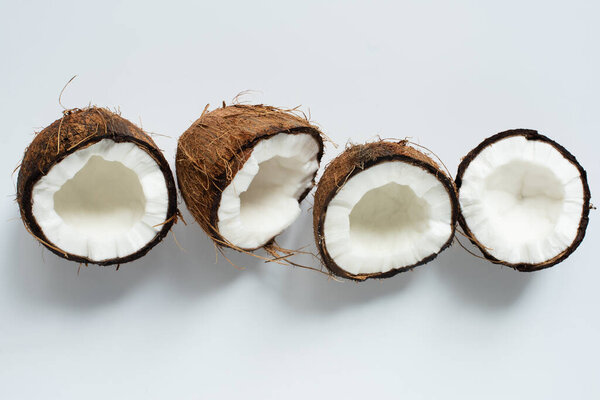 top view of fresh tasty coconut halves on white background
