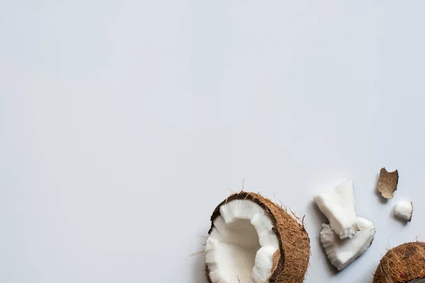 新鮮なおいしいココナッツの半分と白い背景の割れた部分のトップビュー — ストック写真