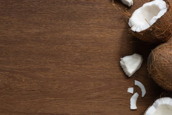 Bovenaanzicht Van Verse Smakelijke Gebarsten Hele Kokosnoten Houten Tafel — Stockfoto