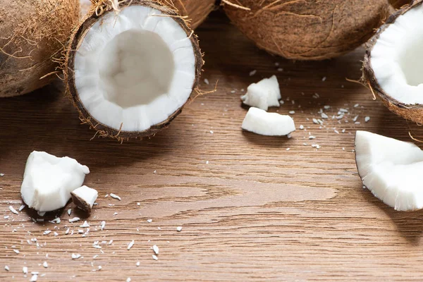 Verse Smakelijke Hele Gebarsten Kokosnoten Vlokken Houten Tafel — Stockfoto