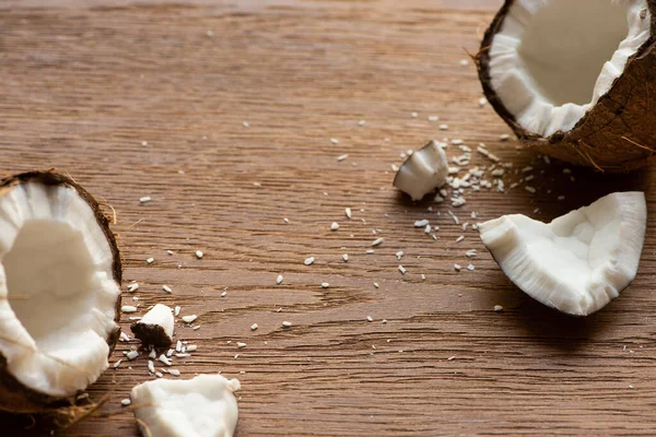 Frische Leckere Kokosnusshälften Neben Flocken Auf Holztisch — Stockfoto