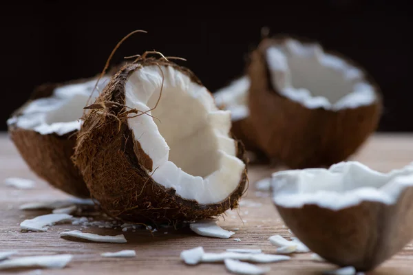 Selectieve Focus Van Verse Smakelijke Kokoshelften Vlokken Houten Tafel Geïsoleerd — Stockfoto