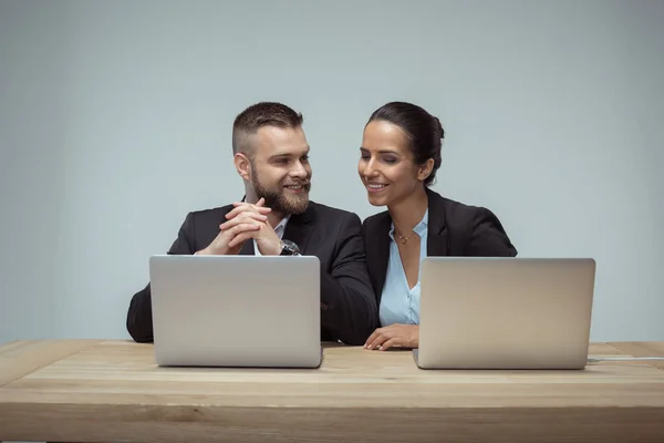 Colegas que trabajan en computadoras portátiles - foto de stock