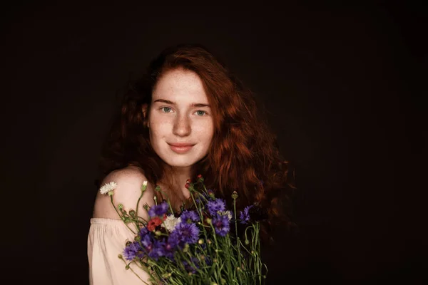 Redhead girl holding cornflowers — Stock Photo