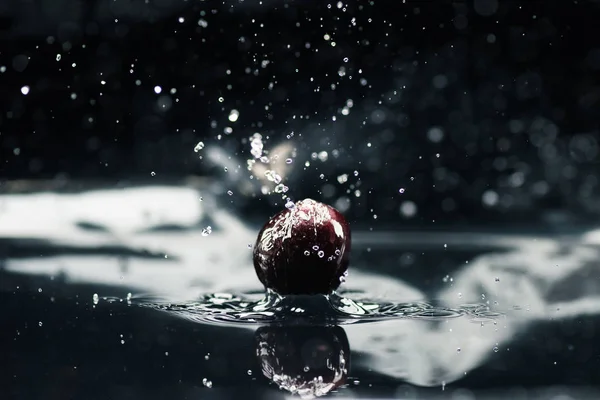 Reife Kirsche fällt ins Wasser — Stockfoto