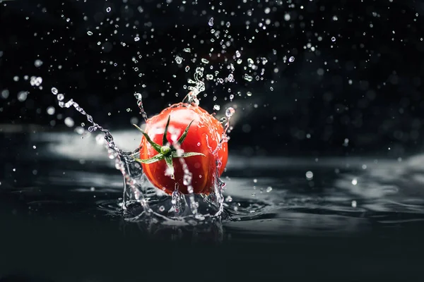 Tomate fraîche tombant dans l'eau — Photo de stock
