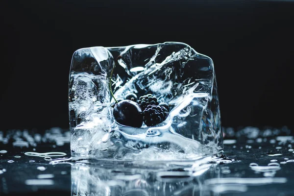 Frozen berries in ice cube — Stock Photo