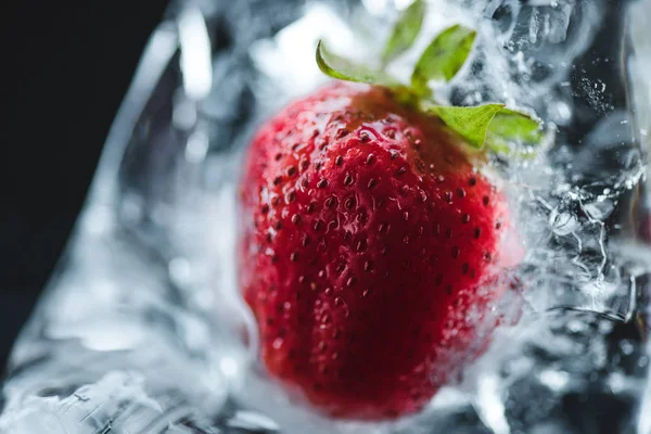 Strawberry frozen in ice cube — Stock Photo