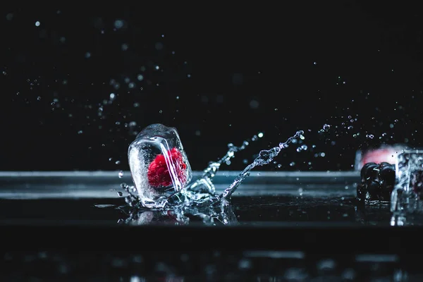 Raspberry frozen in ice cube — Stock Photo