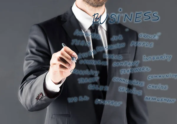 Hombre de negocios escribiendo en panel de vidrio - foto de stock