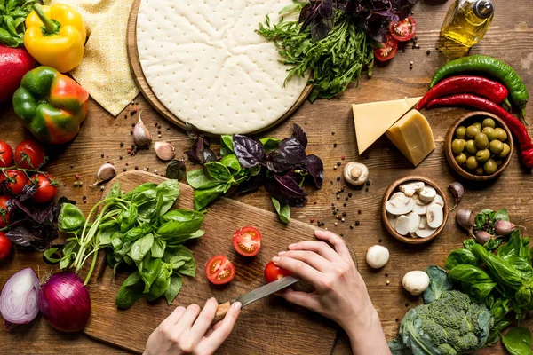 Frau schneidet Kirschtomaten — Stockfoto