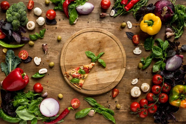 Pizza slice on wooden board — Stock Photo