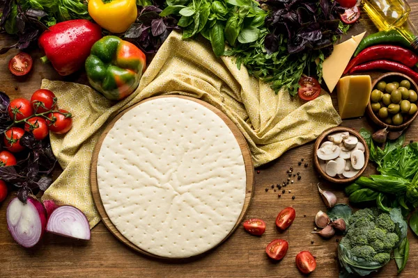 Raw pizza dough and vegetables — Stock Photo