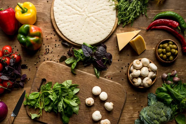 Raw pizza dough and vegetables — Stock Photo