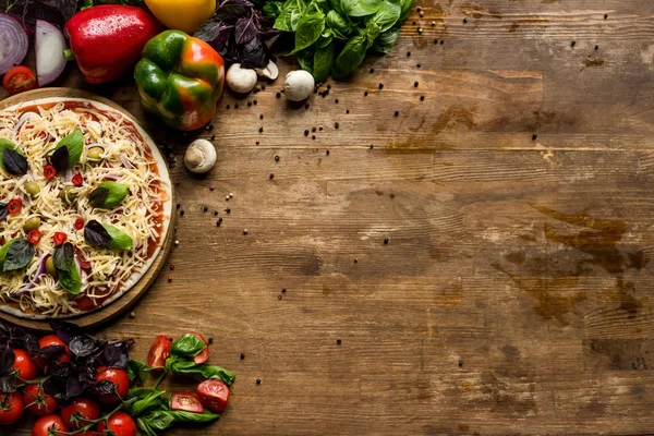 Pizza casera cruda con ingredientes - foto de stock
