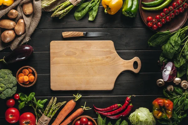 Tabla de cortar y verduras frescas - foto de stock