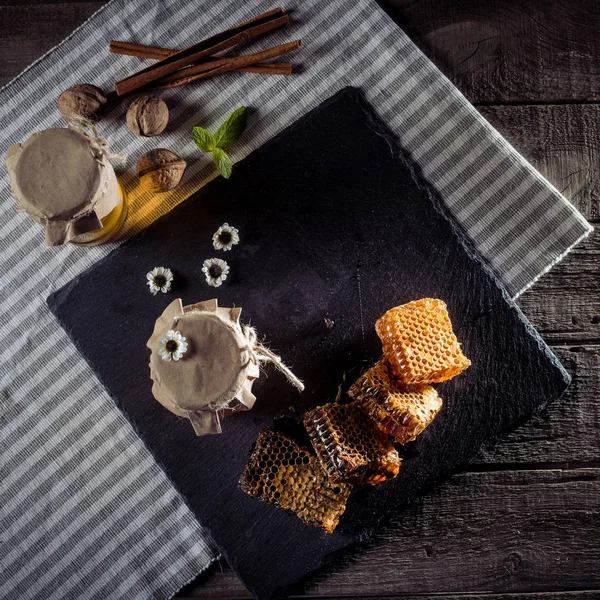 Nids d'abeilles et bocaux en verre au miel — Photo de stock