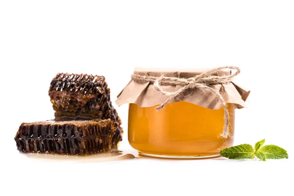 Соты и мед в стеклянной банке — стоковое фото