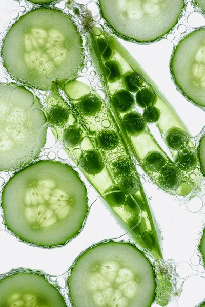 Guisantes verdes y rodajas de pepino - foto de stock