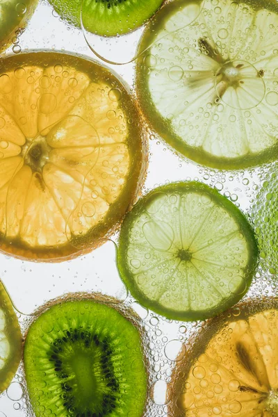 Tranches d'agrumes flottant dans l'eau — Photo de stock