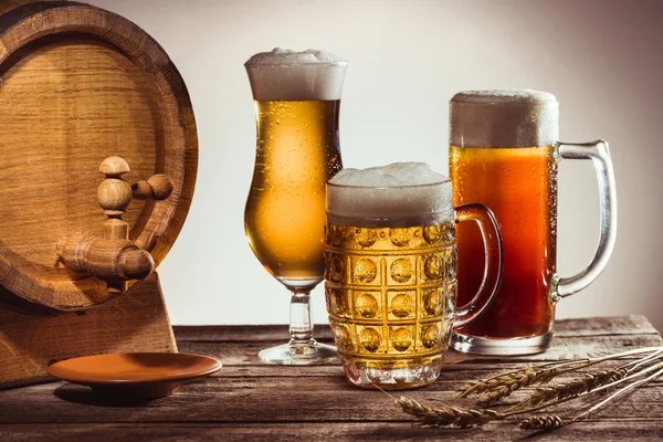 Barrel and different beer in glasses — Stock Photo