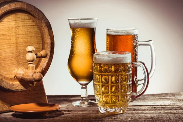 Barril y cerveza diferente en vasos - foto de stock