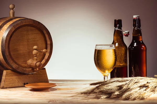 Barril de cerveza, vidrio y botellas - foto de stock