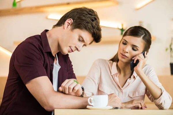 Pareja revisando reloj de pulsera - foto de stock