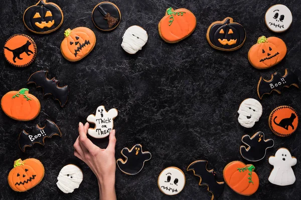 Mujer celebración halloween cookie - foto de stock