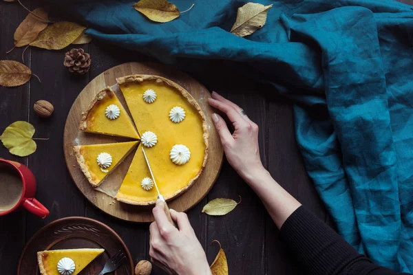 Weibliche Hände schneiden Kürbiskuchen — Stockfoto